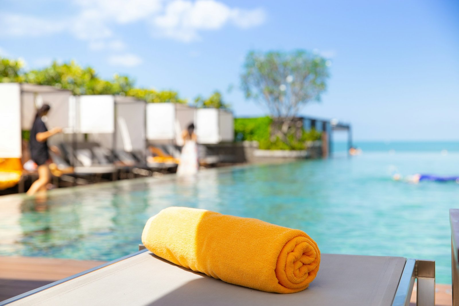 Yellow towel on the bed cushion by the infinity swimming pool.